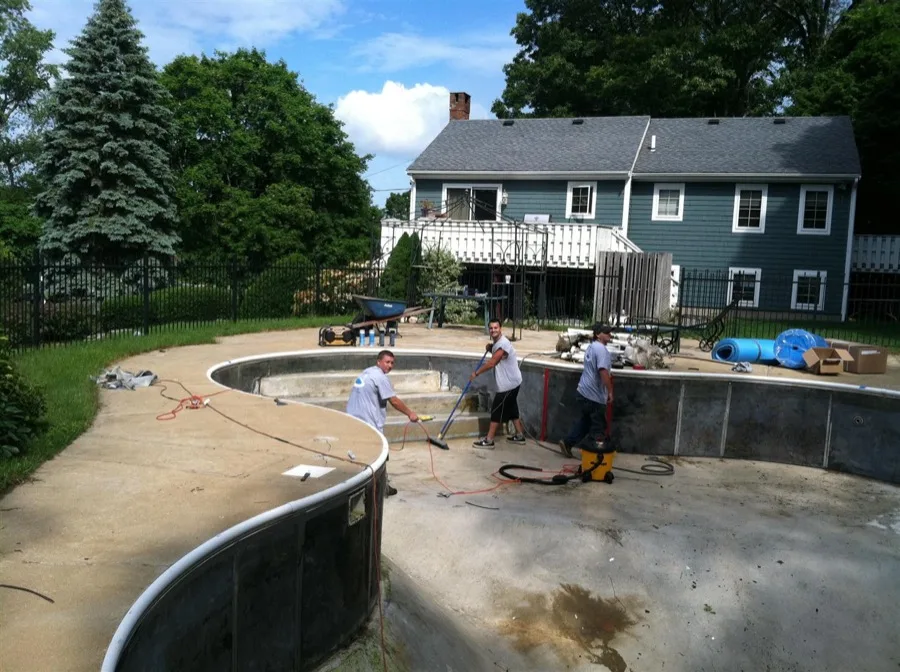 In-ground pool with handrails and patio